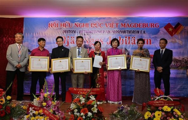 Chu Tuan Duc (1st from R), Minister-Counsellor and Deputy Head of Mission at the Vietnamese Embassy, presents certificates of merit to members with outstanding contributions to the association at the ceremony. (Photo: VNA)