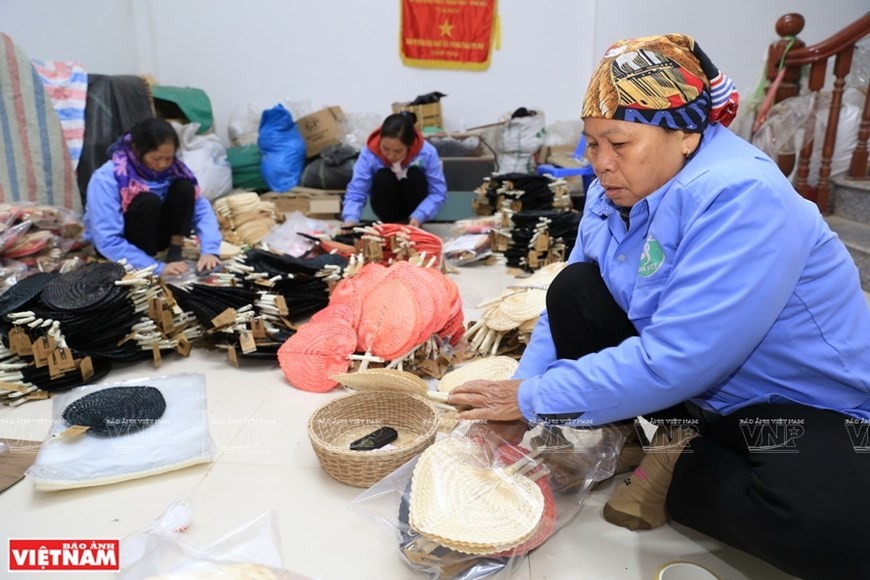 Skilled workers in Dai Viet Company pack Bodhi-leave-shaped fans for export. (Photo: VNP/VNA)