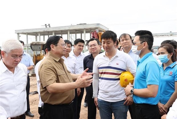 Prime Minister Pham Minh Chinh talks with investors who are implementing projects in Bau Bang Industrial Park in the southern province of Binh Duong. (Source: VNA)