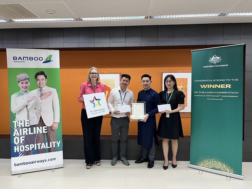 Consul-General Sarah Hooper and Ms Dang Thi Phuong Thao from Bamboo Airways give the prize to Mr. Tran Van Trung