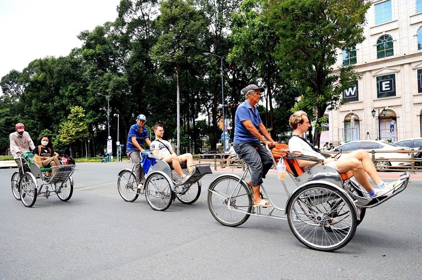 Foreign tourists get around the central area of Ho Chi Minh City by cyclo. (Photo: VNA)