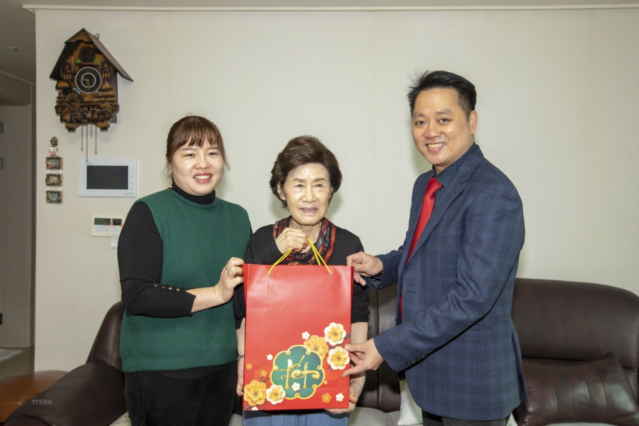 Chargé d'affaires Nguyen Viet Anh (R) presents a gift to a member of Do Thi Thanh Nga's family. (Photo: VNA)