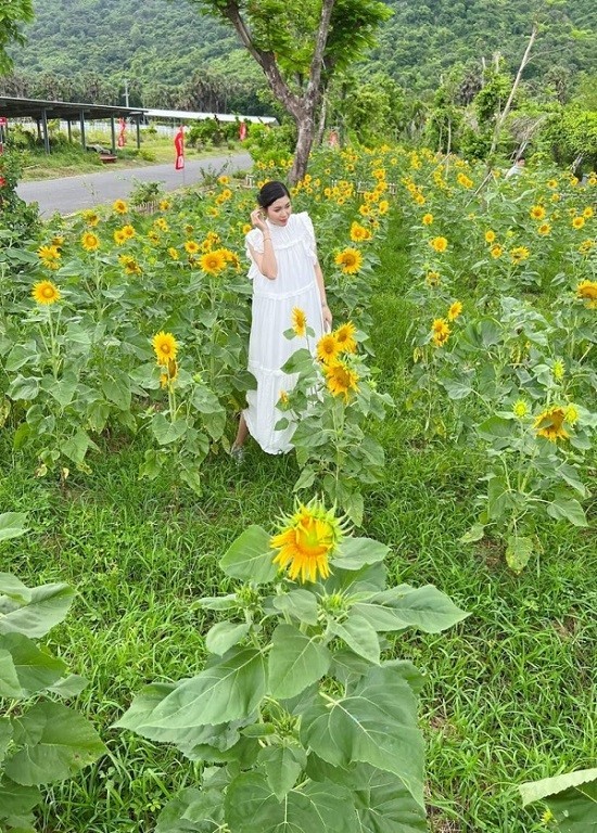 A girl stands in the middle of a sunflower garden