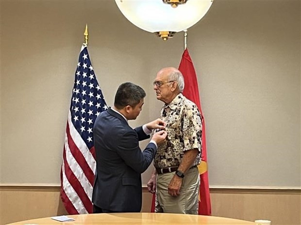 VUFO Vice President and General Secretary Phan Anh Son (L) presents the insignia to Ronald Haeberle, a war correspondent and photographer who took more than 60 photos of the bloody massacre in My Lai on March 16, 1968. (Photo: VNA)