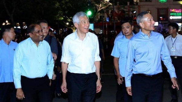 Singaporean Prime Minister Lee Hsien Loong strolling Hanoi streets, trying local food
