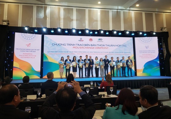The Ministry of Planning and Investment (MPI) and US Agency for International Development (USAID) hand over cooperation pacts to the first 22 Vietnamese pioneering enterprises (PEs) at the forum. (Photo: kinhtevadubao.vn)