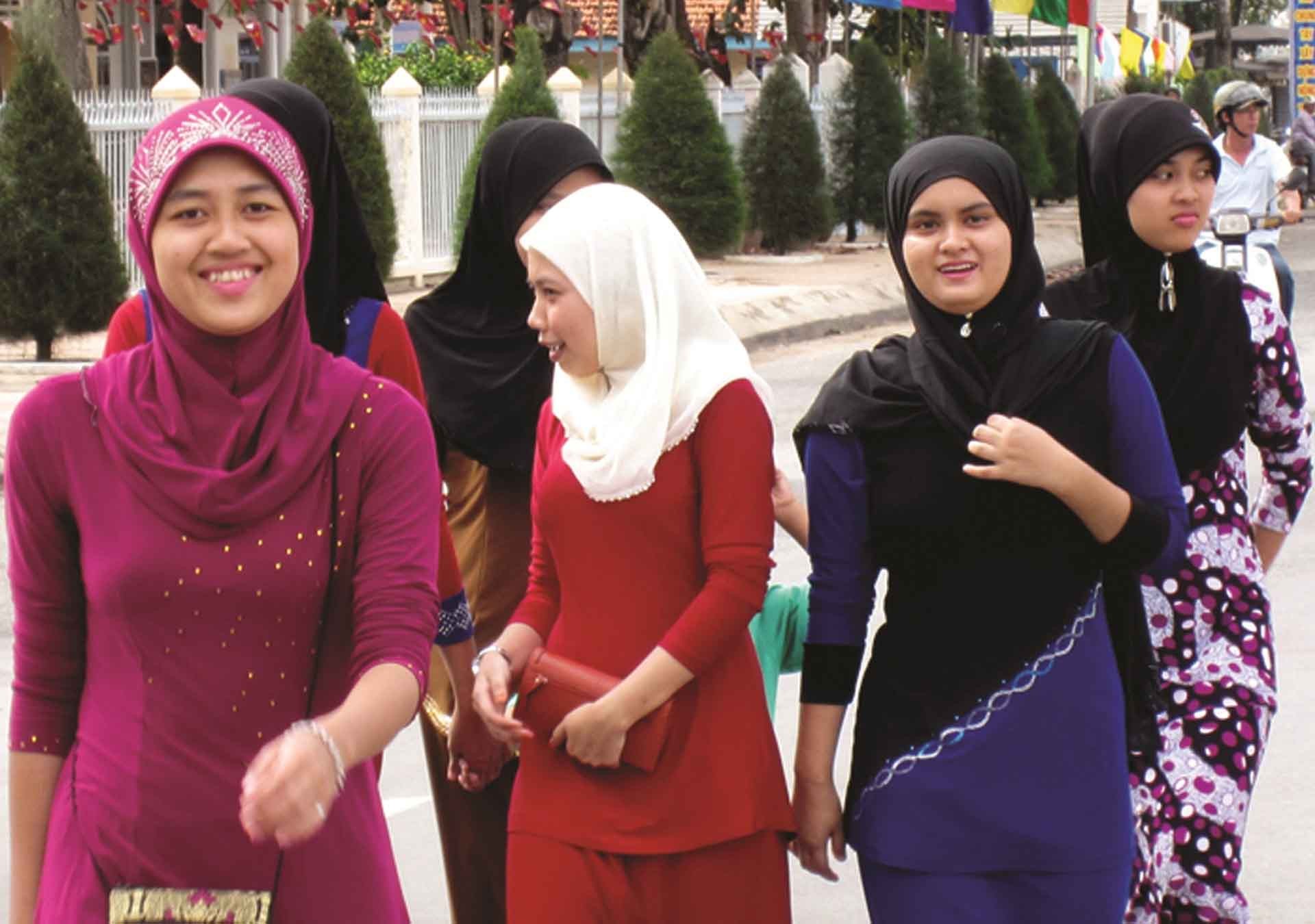Mừng đón Tết Roya Haji các cô gái Chăm với chiếc khăn chùm đầu sặc sỡ và duyên dáng lạ lùng, cùng trang phục truyền thống, tạo thêm nét huyền bí trong từng cử chỉ của họ. (Ảnh: Phương Nghi)