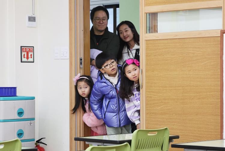 Children due to enter elementary school this year look into a classroom during an orientation day at Youngduck Elementary School in Suwon, Gyeonggi Province, Dec. 26. Yonhap