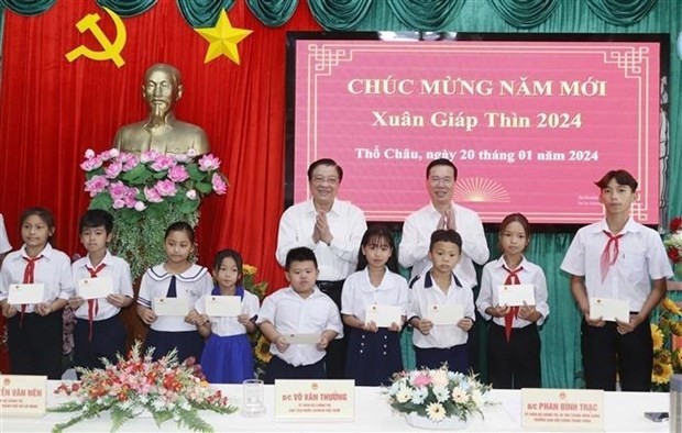 President Vo Van Thuong and Head of the Party Central Commitee's Commission for Internal Affairs Phan Dinh Trac present gifts to students in Tho Chau island commune. (Photo: VNA)