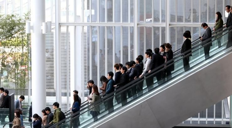 Office workers ride an escalator at an office building in Seoul in this undated file photo. (Source: Yonhap)