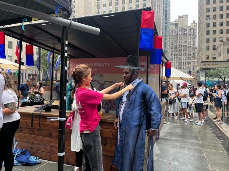 A foreign national tries Korean traditional attire hanbok during the K-tourism roadshow at the Rockefeller Center in New York, July 24, 2023. Yonhap A foreign national tries Korean traditional attire hanbok during the K-tourism roadshow at the Rockefeller Center in New York, July 24, 2023. Yonhap