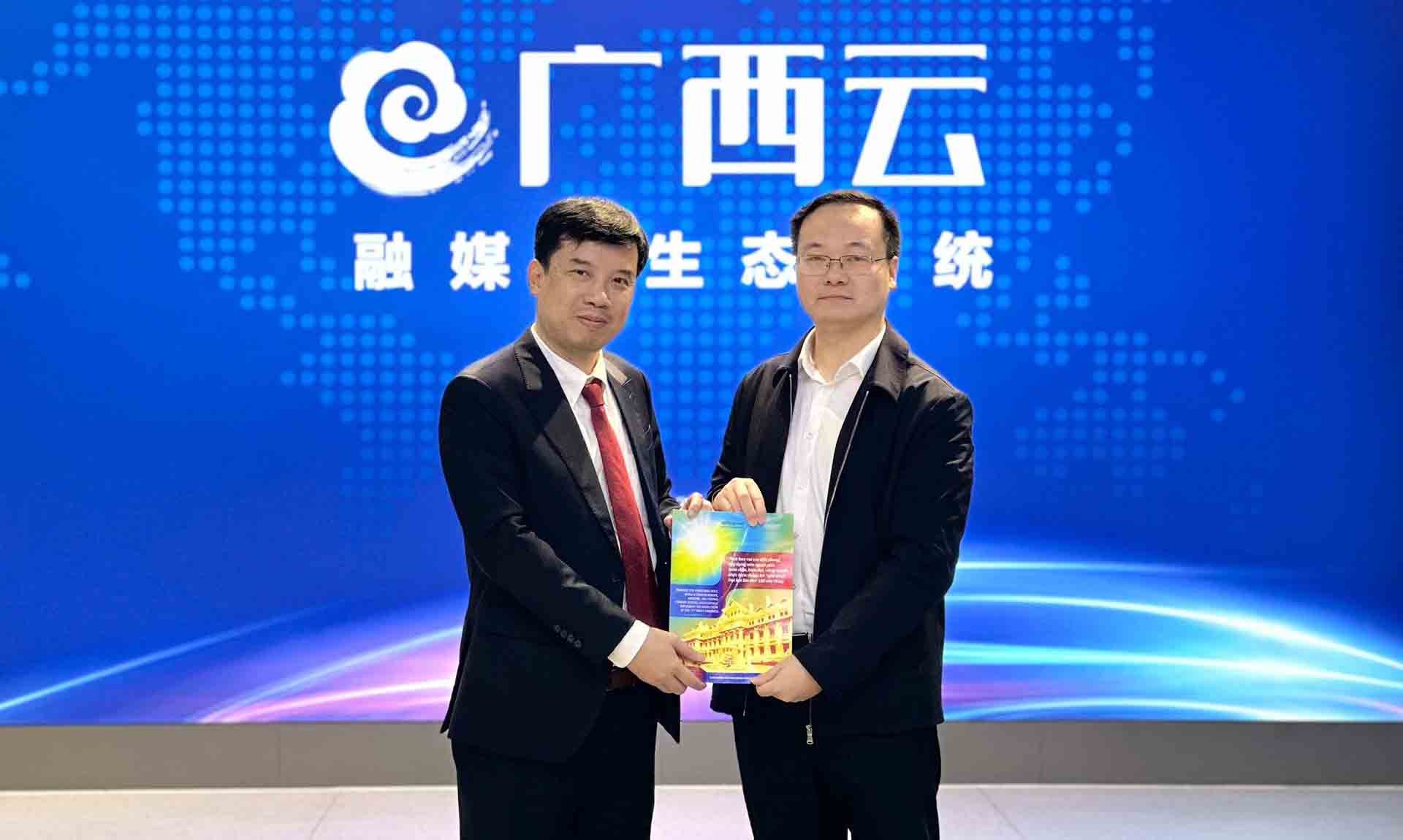 Tổng Bi&ecirc;n tập Nguyễn Trường Sơn trao ấn phẩm của B&aacute;o Thế giới v&agrave; Việt Nam tặng Nhật b&aacute;o Quảng T&acirc;y.