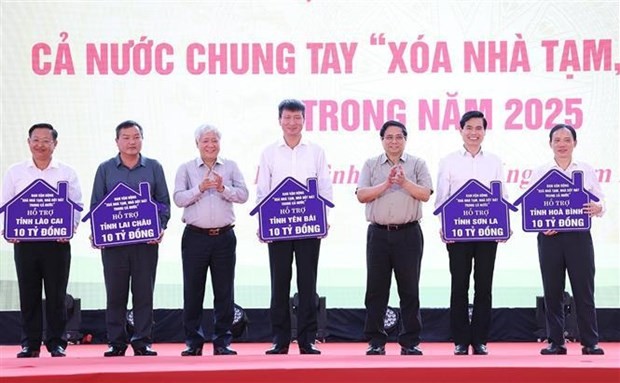 From right: Prime Minister Pham Minh Chinh (3rd) and Chairman of the Vietnam Fatherland Front Central Committee Do Van Chien (5th) hand over the tokens of funds allocated to assist in the removal of temporary and ramshackle houses across several provinces