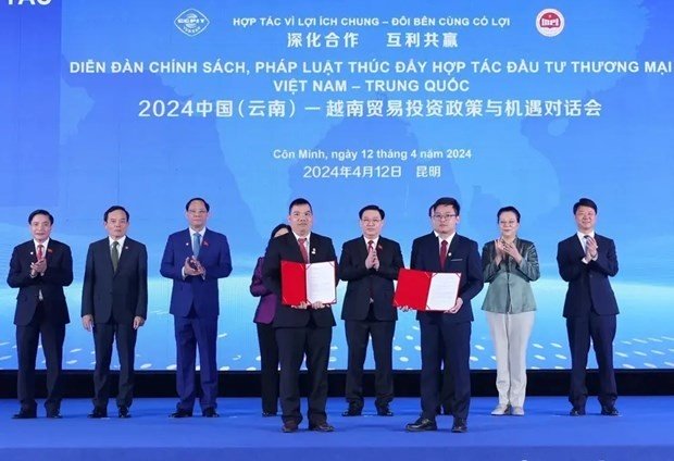 NA Chairman Vuong Dinh Hue witnesses businesses of the two nations exchange Memorandum of Understanding on cooperation. (Photo: VNA)