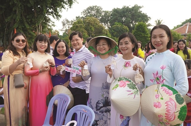 Visitors participating in the Dong Thap Lotus Festival are happy to receive bags of lotus seeds. (Photo: VNA/VNS)