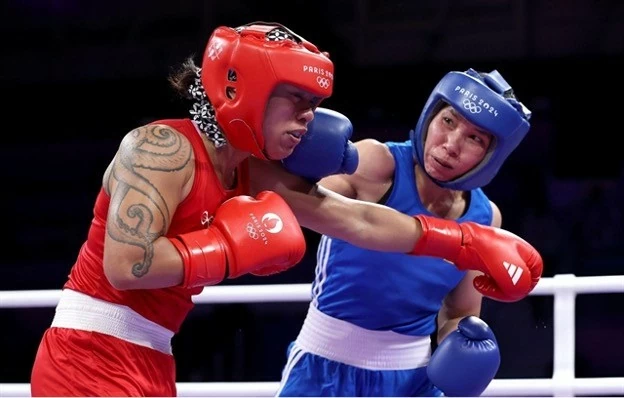 Ha Thi Linh (right) lands a punch on Feofaaki Epenisa from Tonga during the Paris Olympics' women's 60kg first round match on July 27. (Photo doisongphapluat.com.vn) Ha Thi Linh (right) lands a punch on Feofaaki Epenisa from Tonga during the Paris Olympics' women's 60kg first round match on July 27. (Photo doisongphapluat.com.vn)