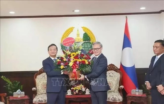 Ambassador Nguyen Minh Tam (left) present flowers to congratulate Lao Foreign Minister Thongsavanh Phomvihane on the 49th anniversary of Laos' National Day. (Photo: VNA) Ambassador Nguyen Minh Tam (left) present flowers to congratulate Lao Foreign Minister Thongsavanh Phomvihane on the 49th anniversary of Laos' National Day. (Photo: VNA)