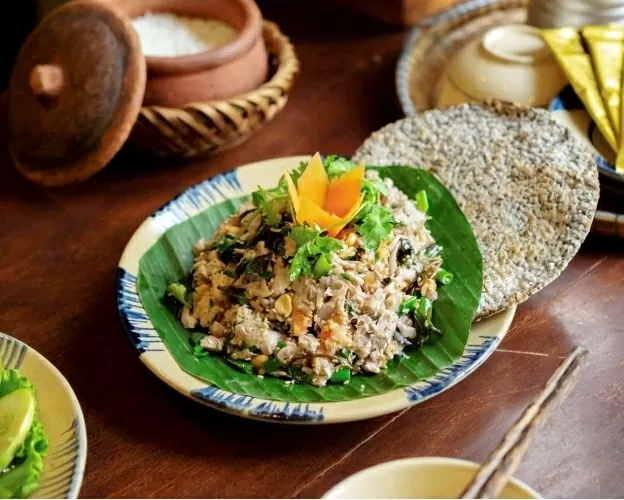 A serving of fig salad with pork and shrimp, accompanied by crispy rice crackers. (Photo: Saigontimes)