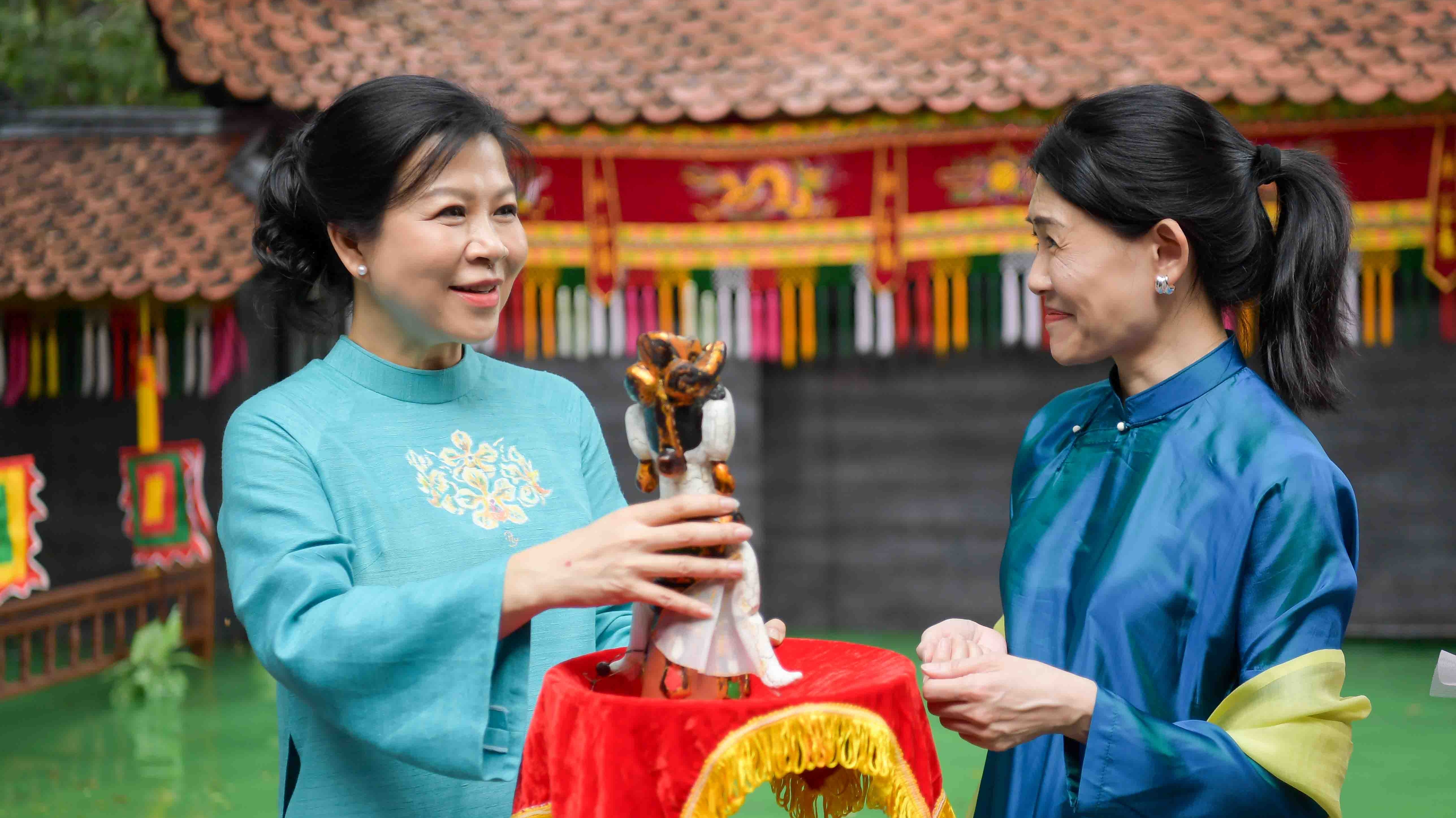 Spouses of Party Geneal Secretary, Singaporean Prime Minister contemplate water puppetry