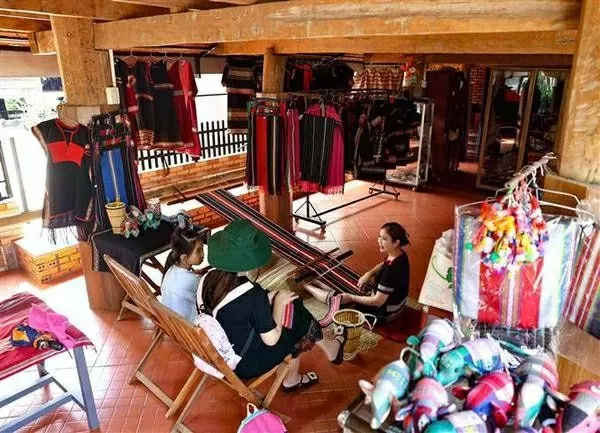Visitors explore and shop for souvenirs made from brocade fabric. (Photo: VNA)