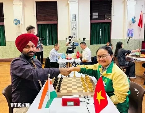 Vietnamese chess player Hoang Thi Bao Tram shakes hands with Indian player Arvinder Preet Singh before the match. (Photo: VNA)