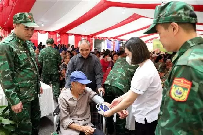 Doctors conduct a preliminary health screening for a wheelchair-bound resident in Dong Dang town, Cao Loc district, Lang Son province. (Photo: VNA)