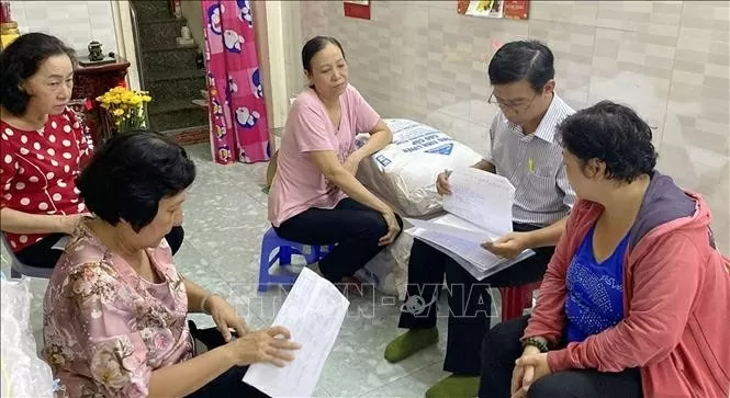 The inspection team on the implementation of the sustainable poverty reduction programme for the 2021-2025 period reviews the list of poor and near-poor households in HCM City’s District 5. (Photo: VNA)