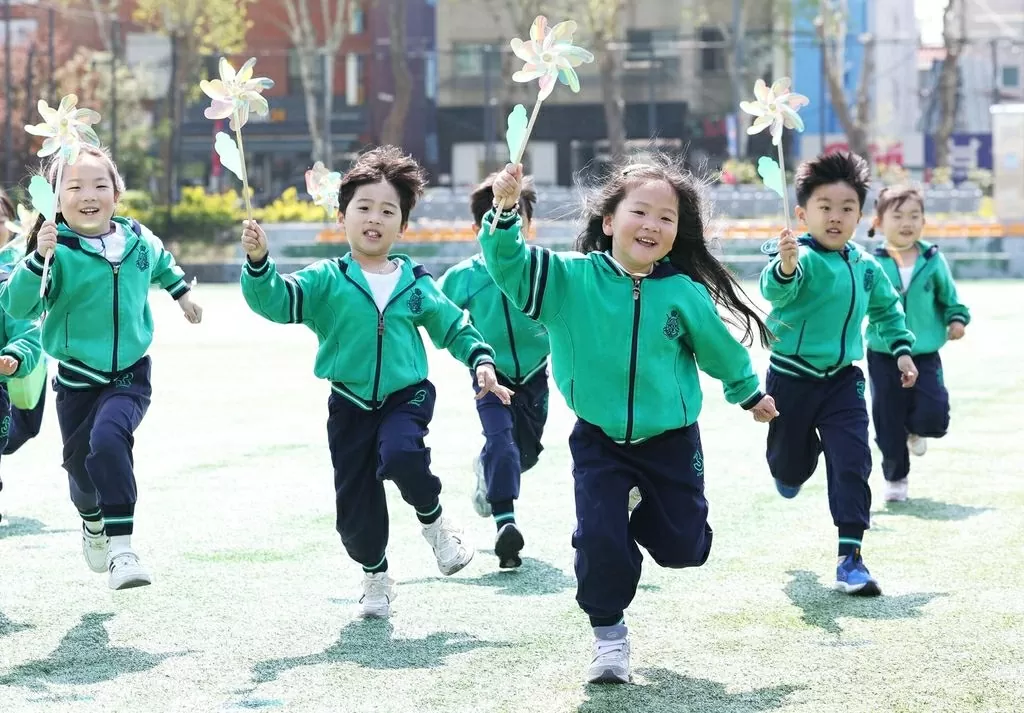 Children run with pinwheels at Suwon Gymnasium in Suwon, Gyeonggi Province, Wednesday. Yonhap