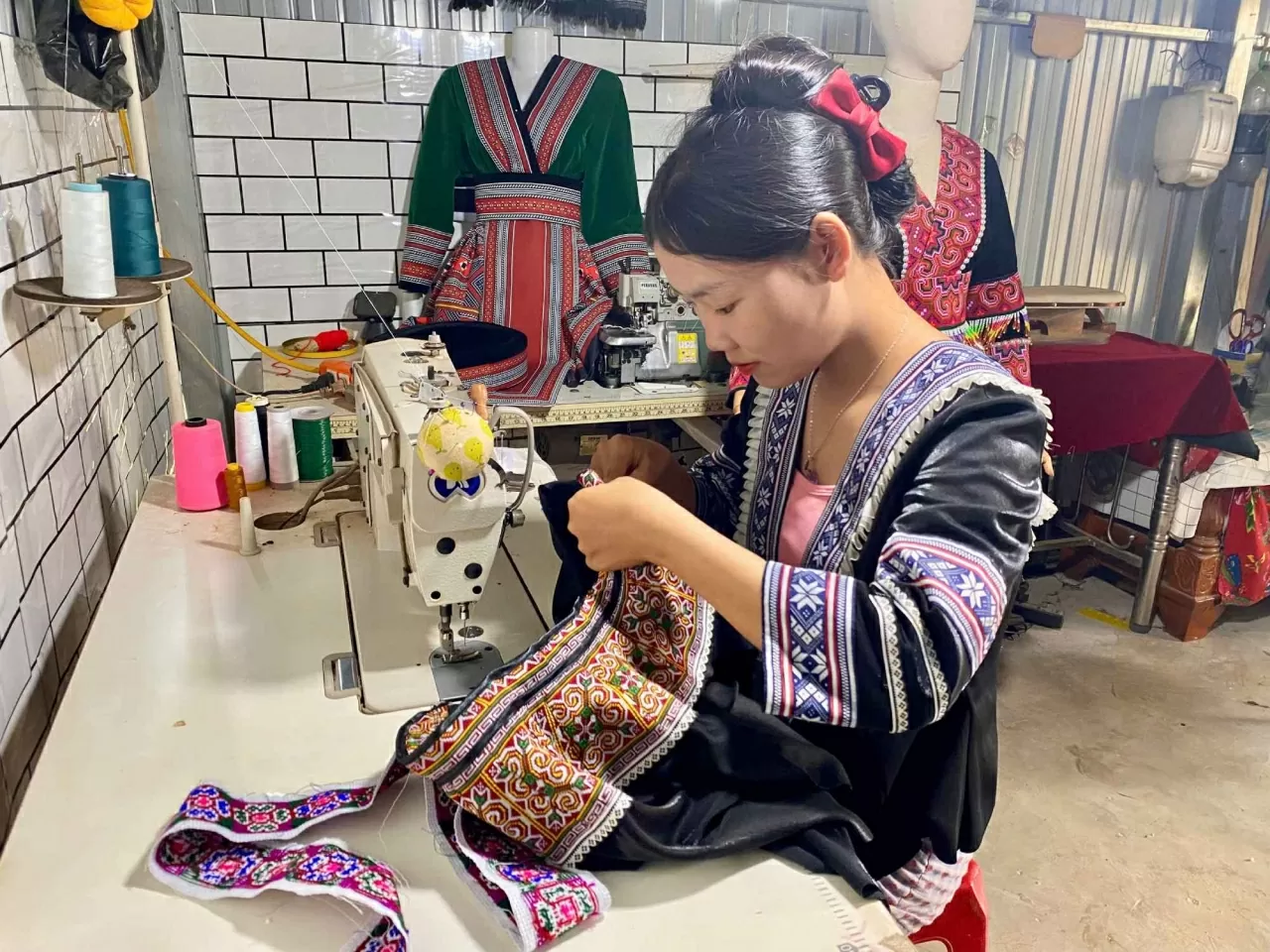 Đôi bàn tay khéo léo của Giàng Thị Pàng thêu lên những bộ trang phục mang đậm bản sắc truyền thống của dân tộc H'Mông. (Ảnh: Xuân Sơn)