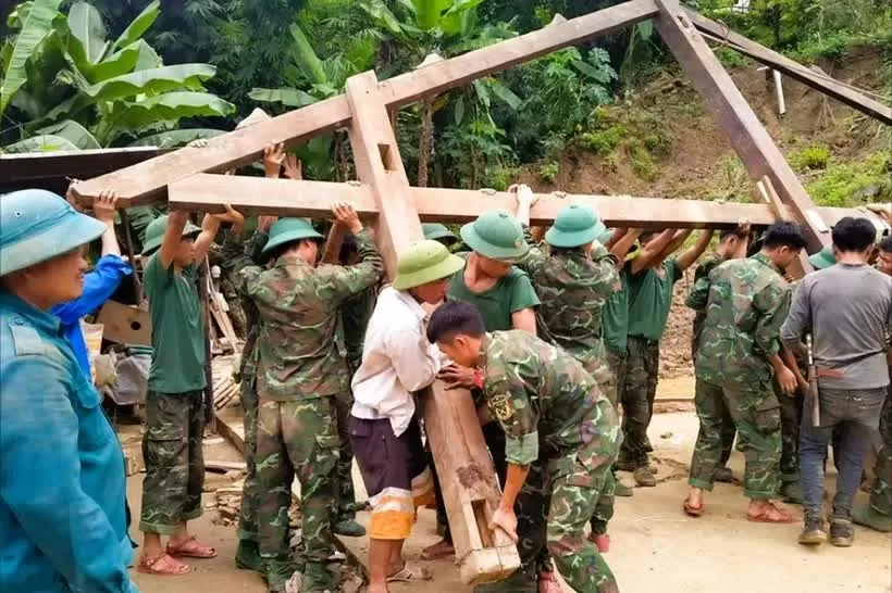 Officers and soldiers of the Tram Tau district armed forces help a poor household in Hat Luu commune build a new house. (Photo: thanhtra)