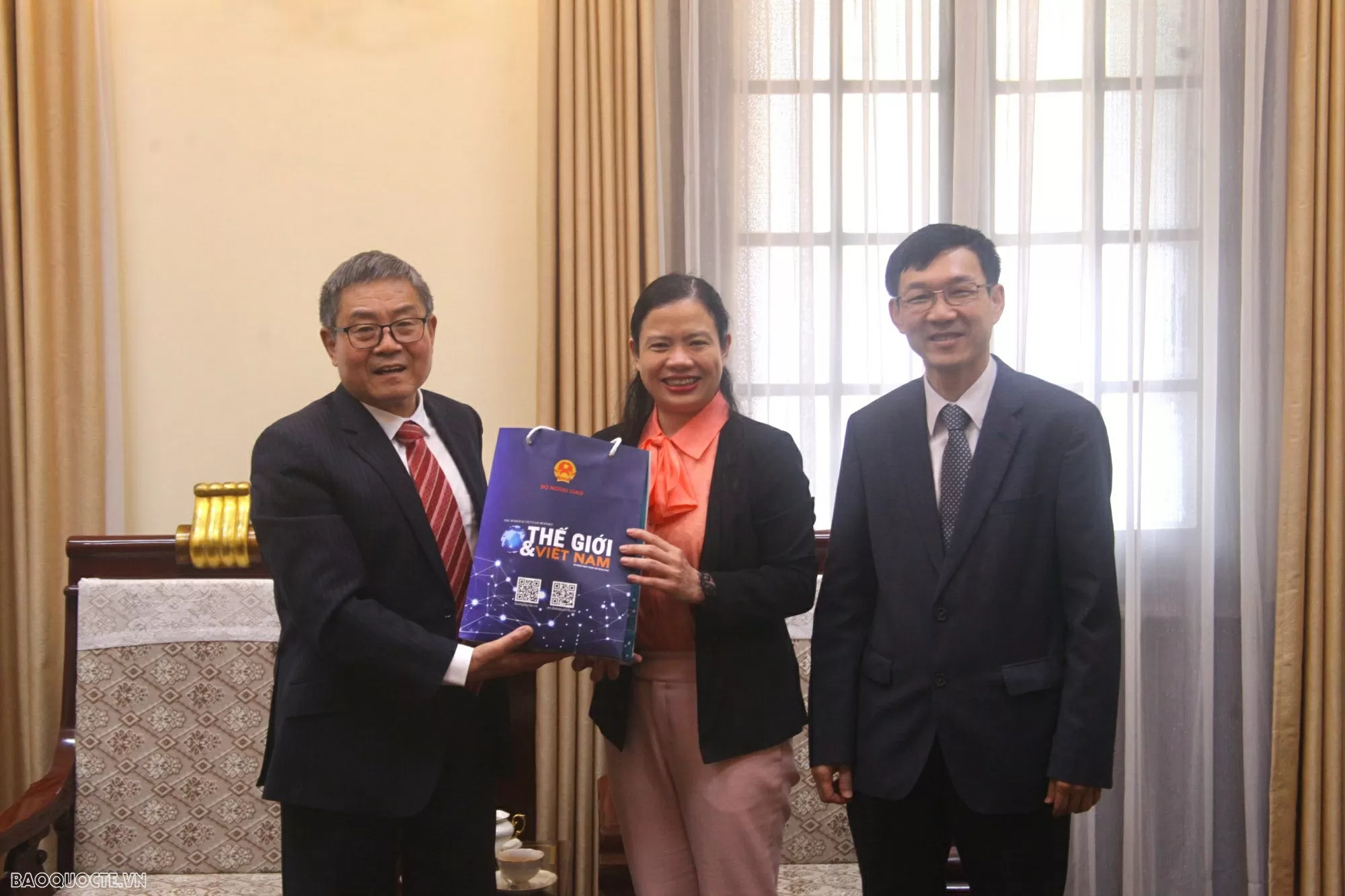 Phó Tổng Biên tập Hoàng Diễm Hạnh cùng nguyên Đại sứ Việt Nam tại Hy Lạp Lê Hồng Trường tặng quà lưu niệm cho ông Đỗ Khải Văn. (Ảnh: Việt Hoàng)