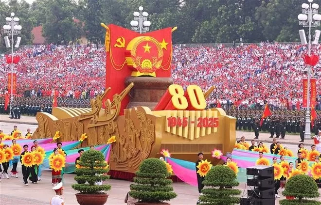 A model vehicle bearing the National Emblem of the Socialist Republic of Viet Nam leads the military parade and mass procession. (Photo: VNA)