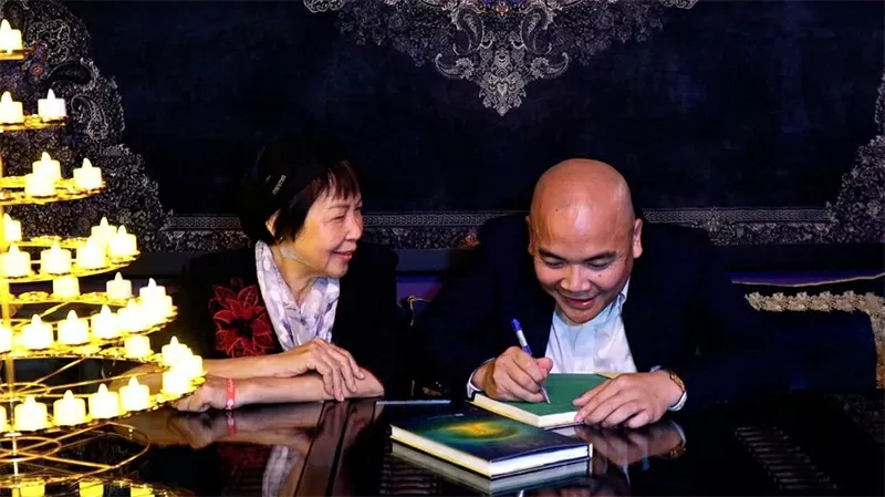 Author Hà Huy Thanh signs books for readers during the 11/11 Book Launch Ceremony at the Valley of Compassion – Disa Valley (Photographer: Lukas Vrtilek and Photo Credit: Disa).