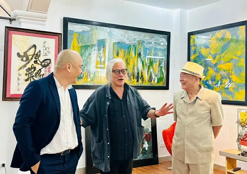 Journalist Xuan Ba visits the art gallery at Disa Valley, accompanied by Hà Huy Thanh and his child (Photographer: Lukas Vrtilek, Photo Credit: Disa).