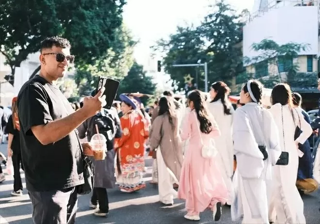A foreigner records moments at the Vietnam Costumes Festival in Hanoi on November 15, 2025. (Photo: sggp.org.vn)