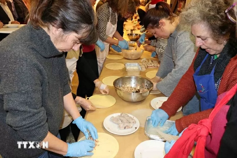 Attendees practice wrapping spring rolls. (Photo: VNA)