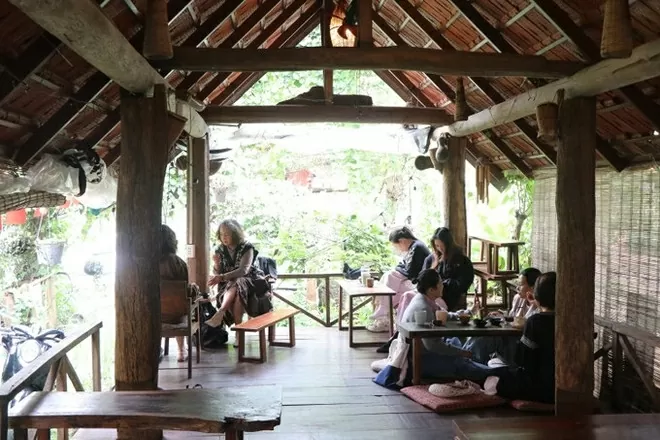 Tourists enjoy coffee at the M&rsquo;Nga Tang Bi stilt house in Ako Dhong village, Buon Ma Thuot ward, Dak Lak province. (Photo: VNA)
