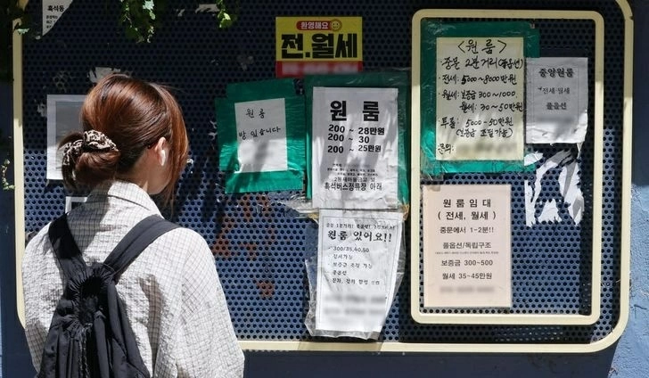A college student looks at a rental listings displayed on a board near Chung-Ang University in Dongjak District, Seoul, Aug. 12. Yonhap