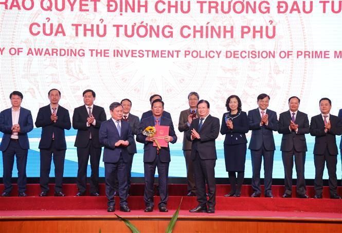 Deputy Prime Minister Trinh Dinh Dung (first, right, front line) hands over investment licence of the 800-million-VND Bao Ninh golf course project to representative of Truong Thinh Group (Photo: VNA)