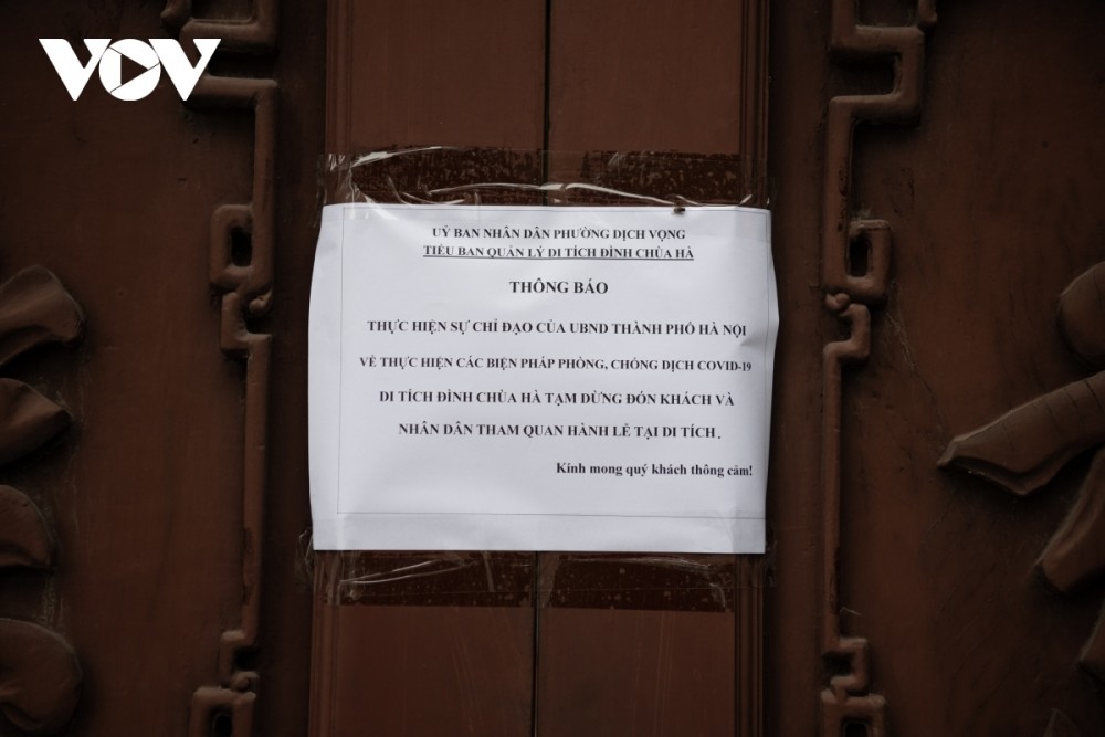 The management board of Ha pagoda places a notice on the door detailing their temporary closure as part of the COVID-19 fight.