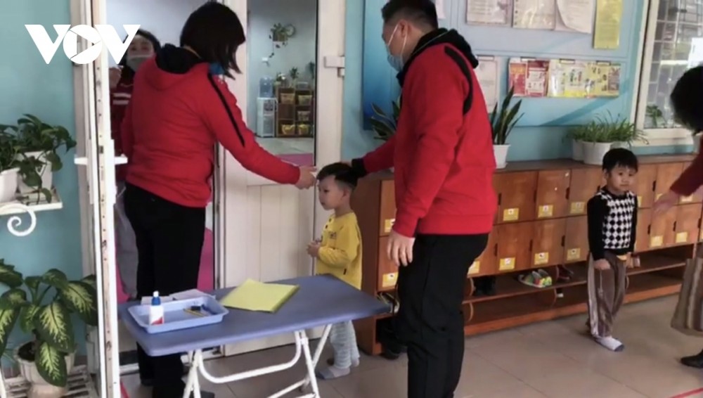 At Nga Tu So Kindergarten in Dong Da district, kids have their body temperatures checked upon arrival, while staff are present to ensure that their hands are thoroughly sanitized before attending class.