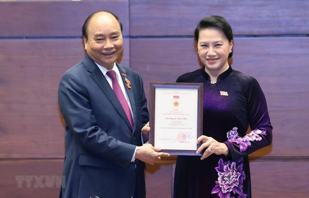 NA Chairwoman Nguyen Thi Kim Ngan presents the insignia for NA operations to Politburo member and Prime Minister Nguyen Xuan Phuc, who is deputy to the 11th, 13th, 14th National Assemblies (Photo: VNA)
