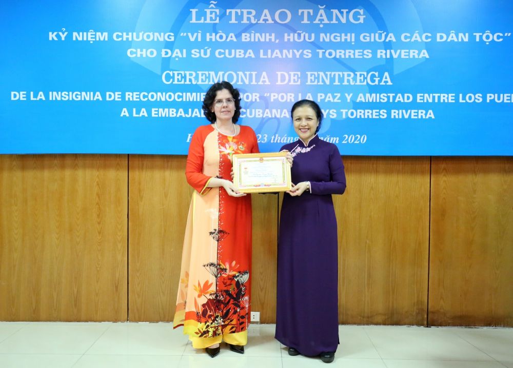 VUFO President, Ambassador Nguyen Phuong Nga (R) presents the insignia to outgoing Cuban Ambassador to Vietnam Lianys Torres Rivera (Photo: VNA)