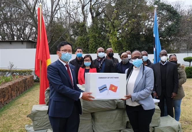 Đại sứ Hoàng Văn Lợi trao 50.000 khẩu trang cho Đại biện lâm thời Botswana tại Nam Phi Gaogane Tiny Mothobi trước sự chứng kiến của đại diện Đại sứ quán hai nước. (Nguồn: TTXVN)