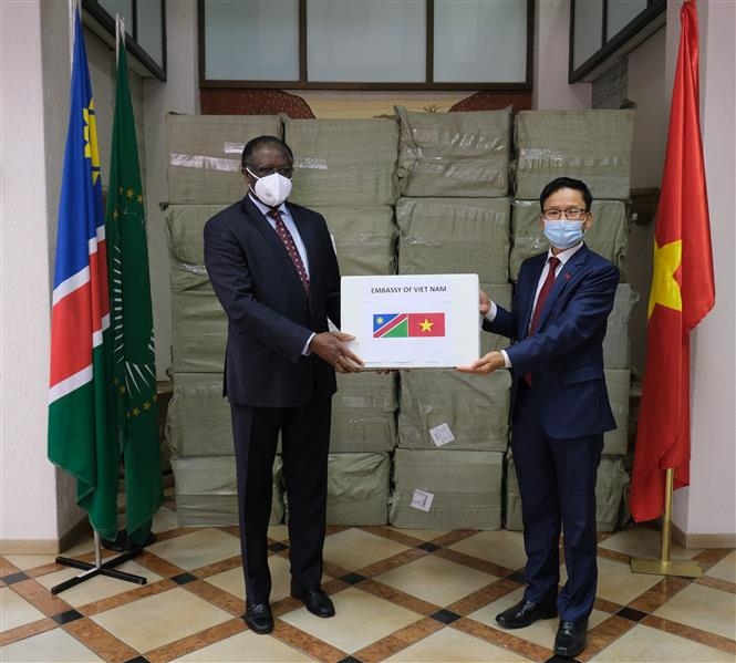 Đại sứ Hoàng Văn Lợi (phải) trao 50.000 khẩu trang cho Đại sứ Namibia tại Nam Phi Veiccoh K. Nghiwete. (Nguồnn: TTXVN)