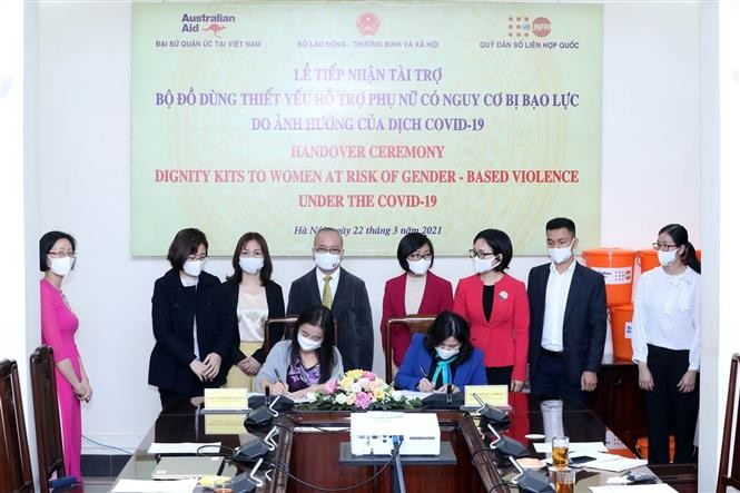 Bà Naomi Kitahara, Trưởng đại diện Quỹ Dân số Liên hợp quốc tại Việt Nam (bên trái) và Thứ trưởng Bộ Lao động – Thương binh và Xã hội Nguyễn Thị Hà (bên phải) ký bàn giao bộ đồ dùng thiết yếu hỗ trợ phụ nữ có nguy cơ bạo lực do ảnh hưởng của dịch Covid-19