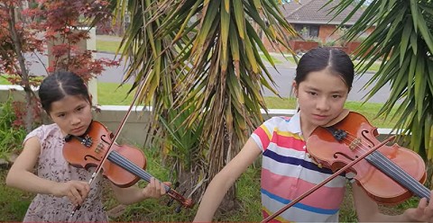 Hai cháu Alice và Luce chơi violin bài Nối vòng tay lớn (Nguồn; Vietnamplus)