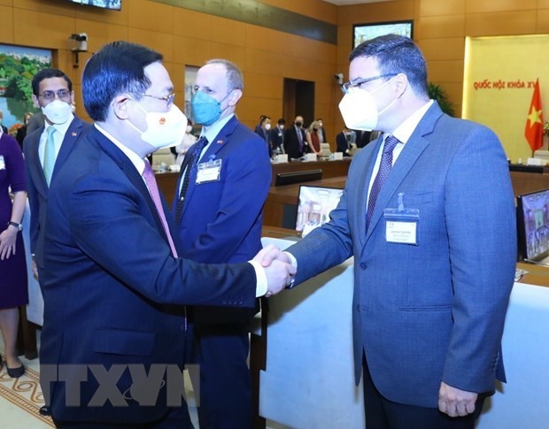 NA Chairman Vuong Dinh Hue (L) greets participants in the meeting in Hanoi on March 9. (Photo: VNA)
