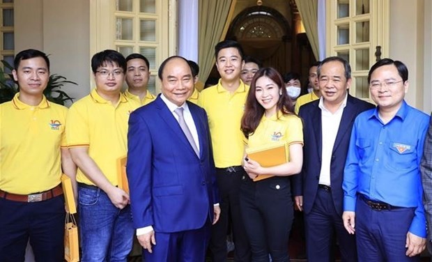 President Nguyen Xuan Phuc (third, left) and the outstanding young people pose for a group photo. (Source: VNA)