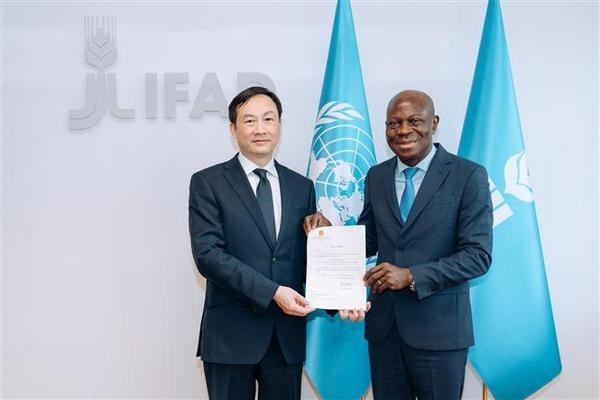 Permanent Representative of Vietnam to the International Fund for Agricultural Development (IFAD) Duong Hai Hung (L) presents his credentials to IFAD President Gilbert F. Houngbo. (Photo: VNA)